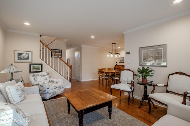 living room featuring an inviting chandelier, crown molding, and wood-type flooring