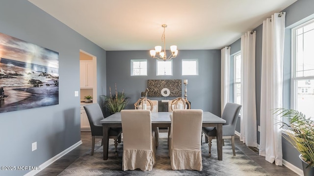 dining room with a wealth of natural light, dark hardwood / wood-style flooring, and a chandelier