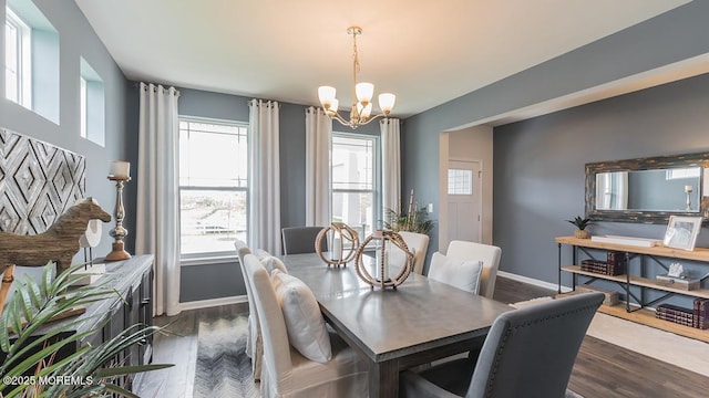 dining space featuring plenty of natural light, dark wood-type flooring, and an inviting chandelier