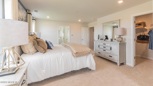 carpeted bedroom with a walk in closet, ensuite bathroom, and a closet