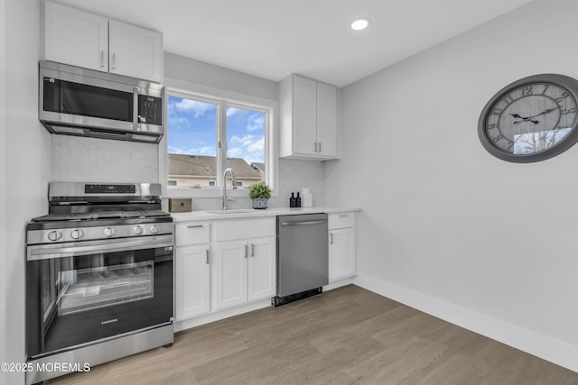 kitchen featuring white cabinetry, sink, and appliances with stainless steel finishes