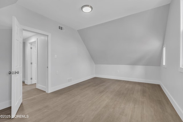 bonus room with lofted ceiling and light hardwood / wood-style flooring