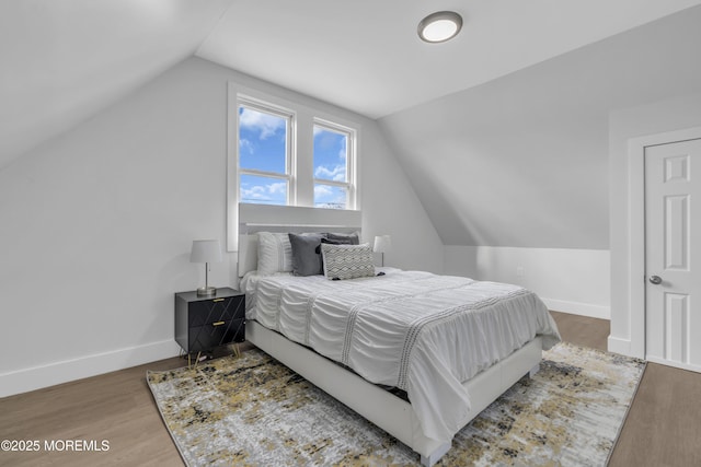 bedroom with hardwood / wood-style floors and lofted ceiling