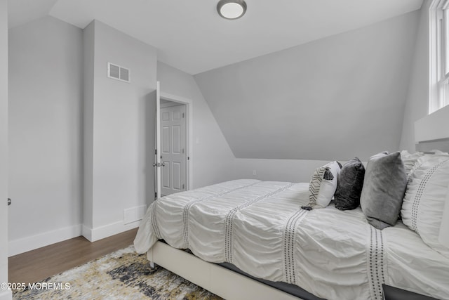 bedroom featuring wood-type flooring and lofted ceiling