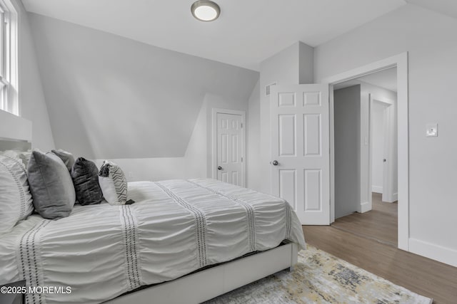 bedroom featuring hardwood / wood-style floors and lofted ceiling