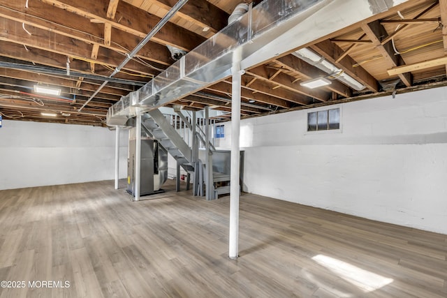 basement with heating unit and wood-type flooring