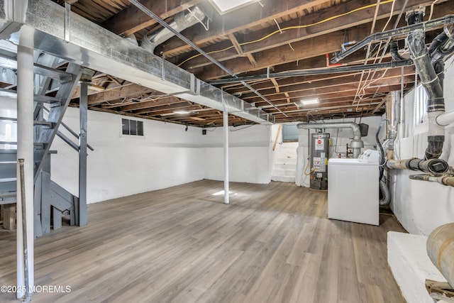 basement with washer / clothes dryer, water heater, and hardwood / wood-style floors