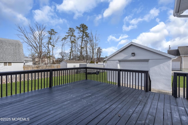 wooden terrace featuring a garage, a storage shed, and a yard