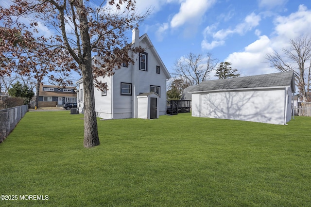 rear view of property featuring a yard and a storage shed