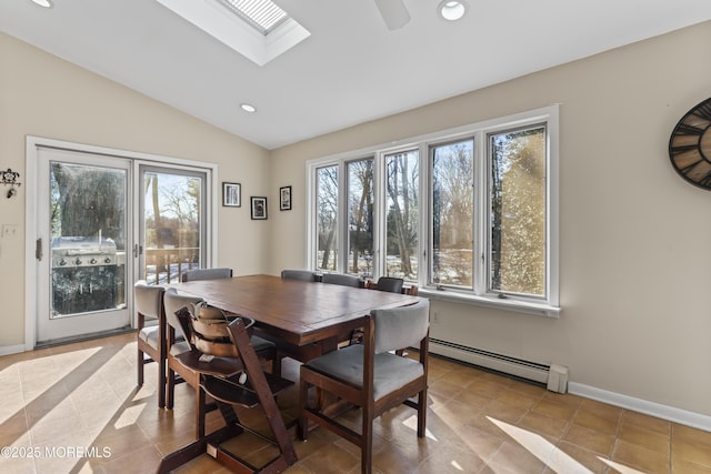 dining space with a baseboard heating unit, lofted ceiling with skylight, and light tile patterned floors