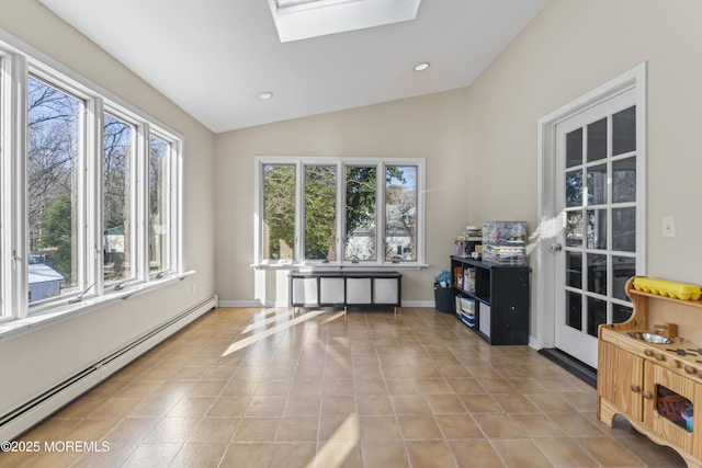 interior space featuring a baseboard heating unit and vaulted ceiling with skylight