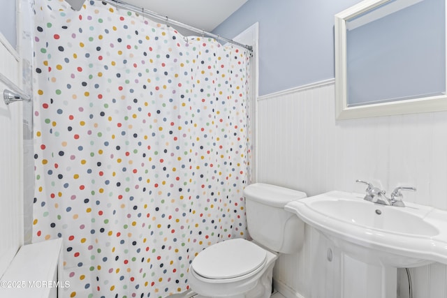 bathroom featuring sink, curtained shower, and toilet