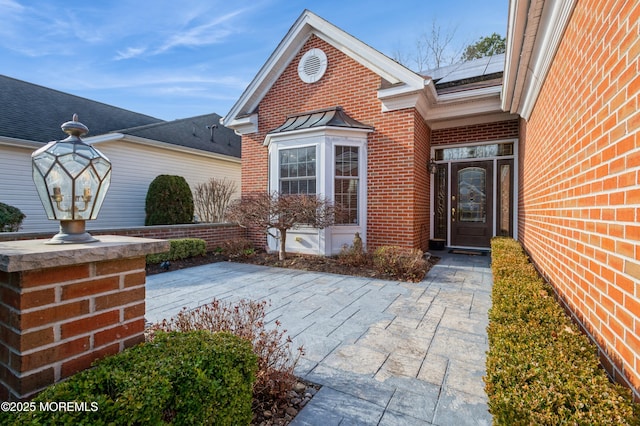 entrance to property with a patio area and solar panels