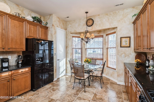 kitchen with hanging light fixtures, stove, a notable chandelier, and black fridge