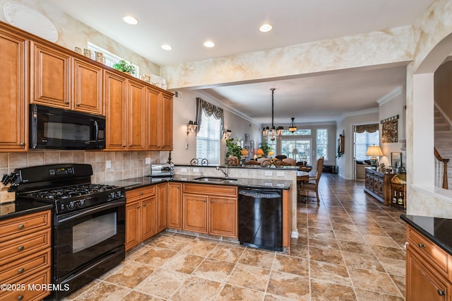 kitchen featuring a chandelier, ornamental molding, kitchen peninsula, and black appliances