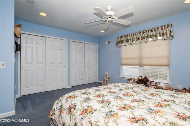 carpeted bedroom featuring ceiling fan and two closets