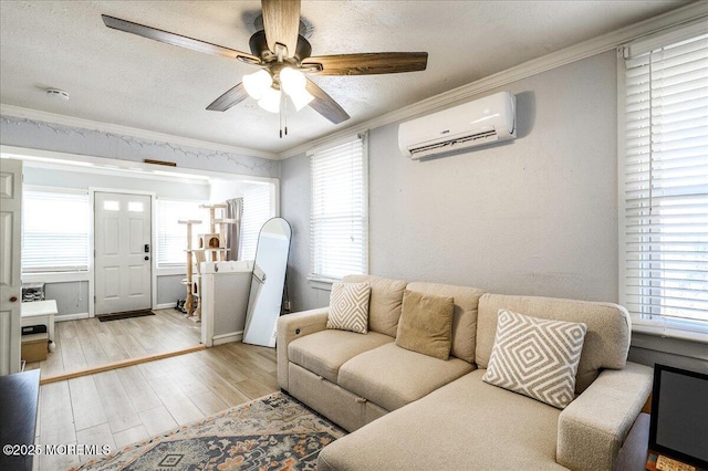 living room featuring a wall mounted air conditioner, a textured ceiling, ceiling fan, crown molding, and light hardwood / wood-style floors