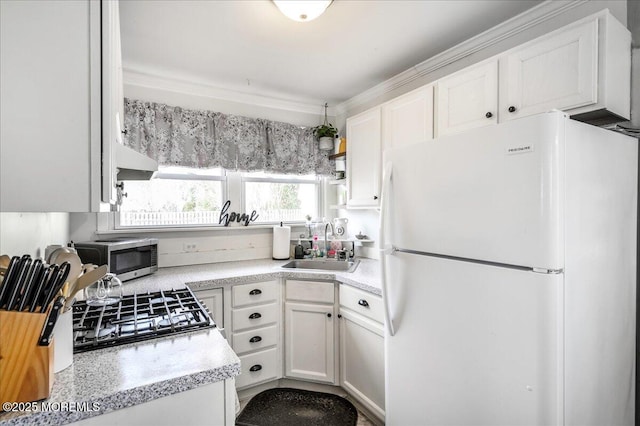 kitchen with white cabinets, crown molding, sink, and appliances with stainless steel finishes