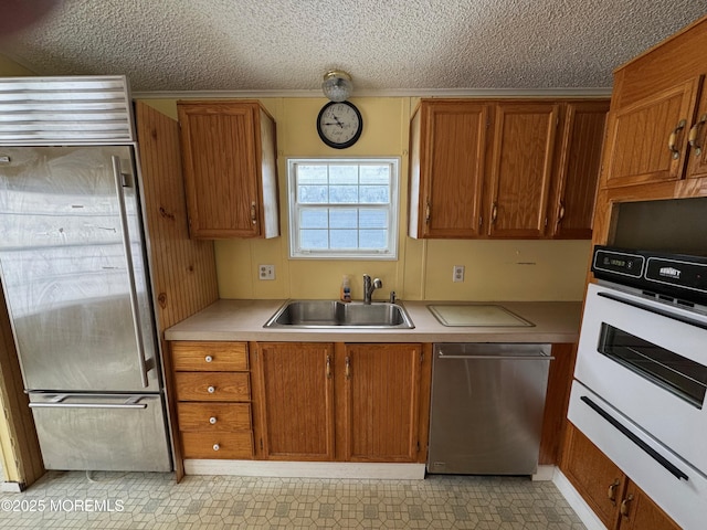 kitchen featuring appliances with stainless steel finishes, a textured ceiling, and sink