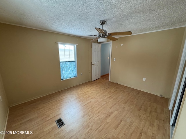 spare room with ceiling fan, light hardwood / wood-style floors, and a textured ceiling