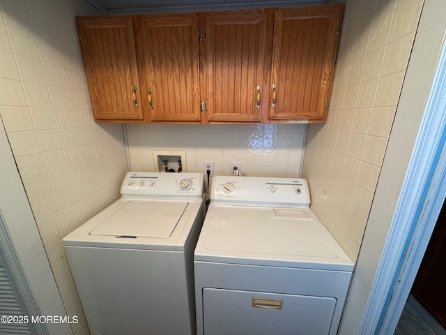 washroom with washer and clothes dryer and cabinets