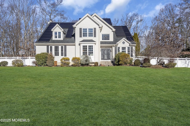 view of front of property with a front yard and solar panels