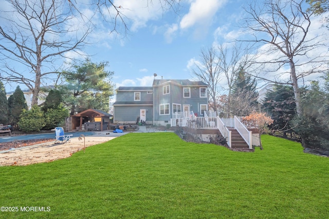 rear view of house featuring a lawn and a deck