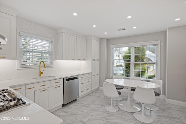 kitchen featuring stainless steel appliances, white cabinets, sink, and light stone counters