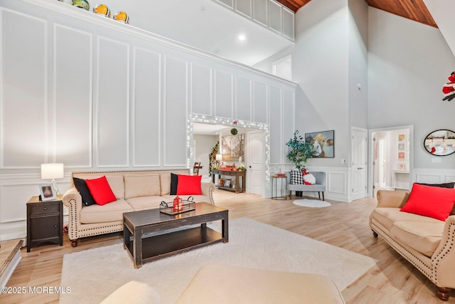 living room with light wood-type flooring and a high ceiling