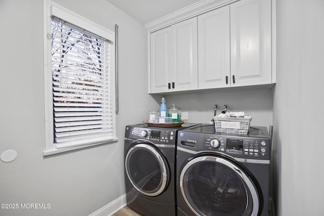 laundry area featuring washer and clothes dryer and cabinets