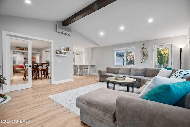 living room featuring a wall mounted air conditioner, lofted ceiling with beams, and light hardwood / wood-style flooring