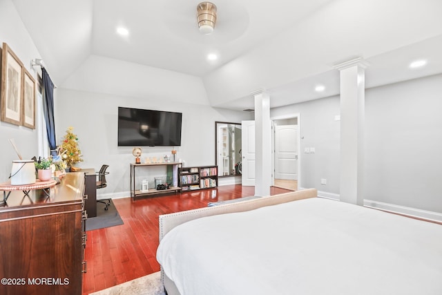 bedroom with hardwood / wood-style floors, decorative columns, vaulted ceiling, and ceiling fan