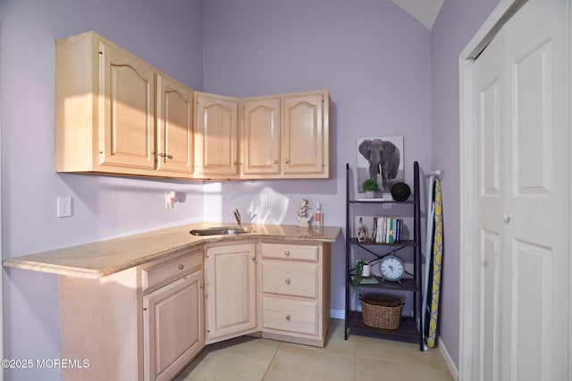 kitchen featuring light brown cabinetry, light tile patterned floors, and sink