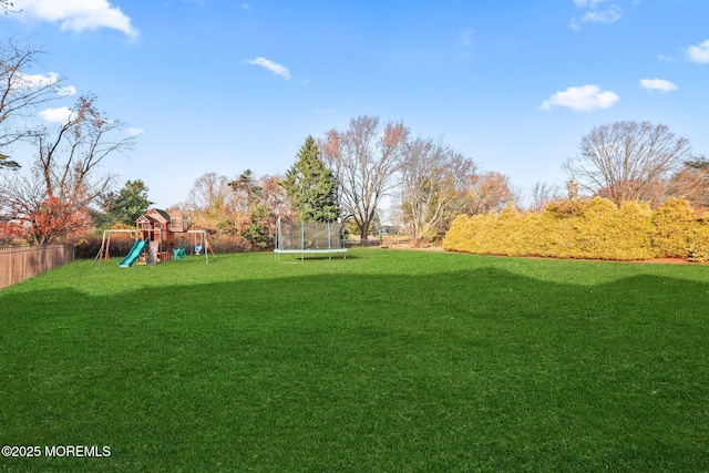 view of yard with a playground and a trampoline