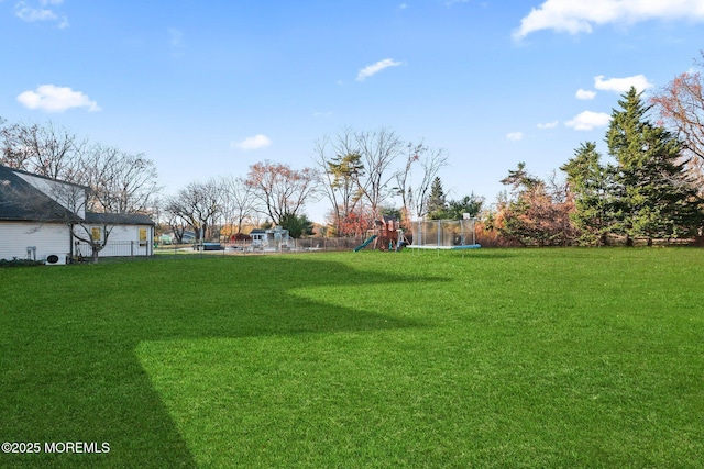 view of yard with a playground and a trampoline