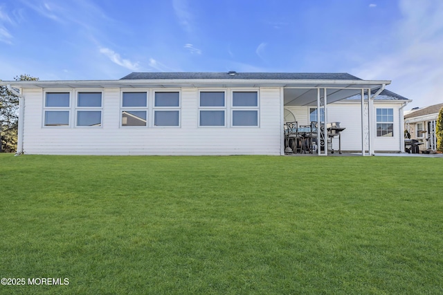 rear view of property with a lawn