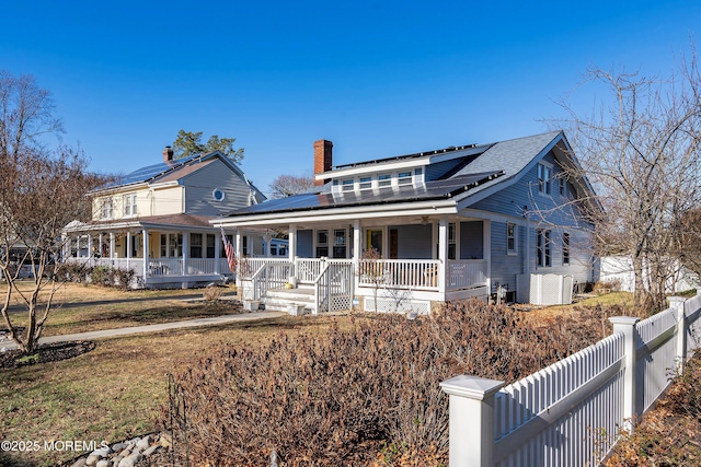 view of front facade with a porch and solar panels