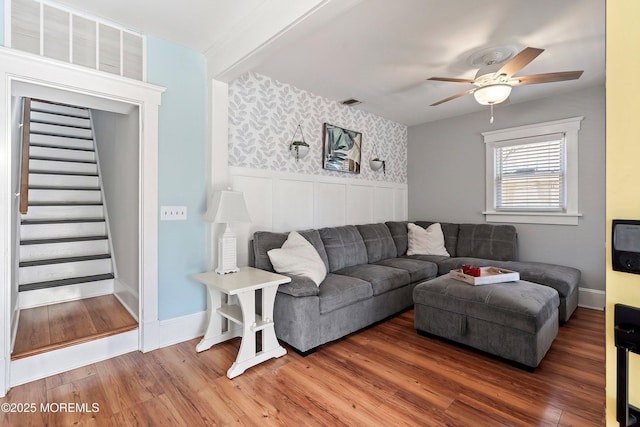 living room featuring beam ceiling, ceiling fan, and wood-type flooring