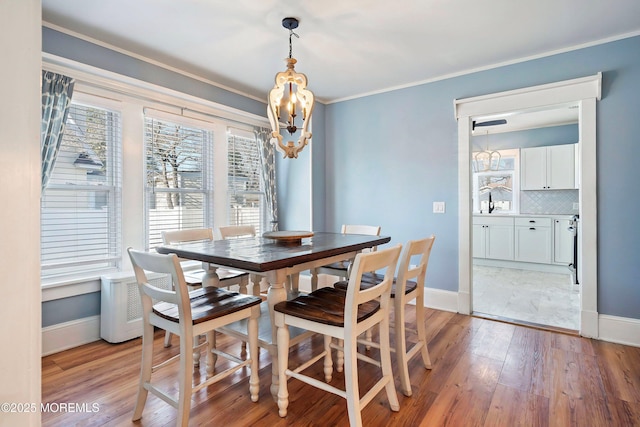 dining room featuring light hardwood / wood-style floors and crown molding