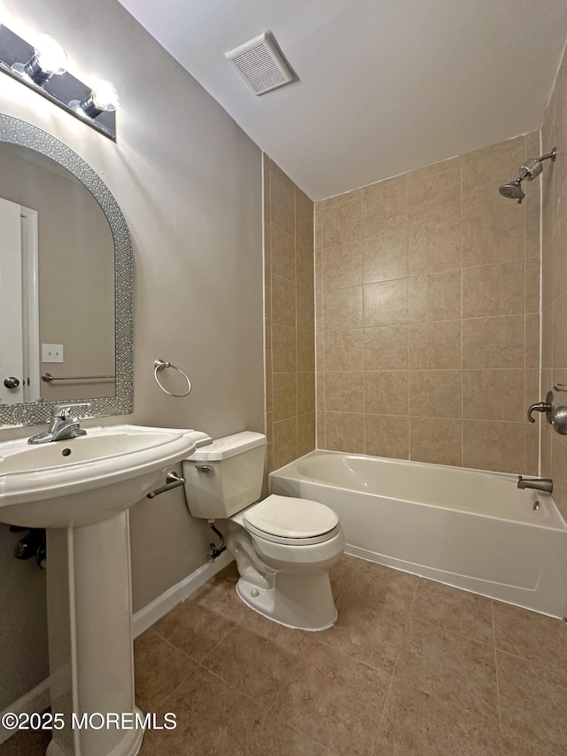 full bathroom with tile patterned floors, tiled shower / bath combo, toilet, and sink