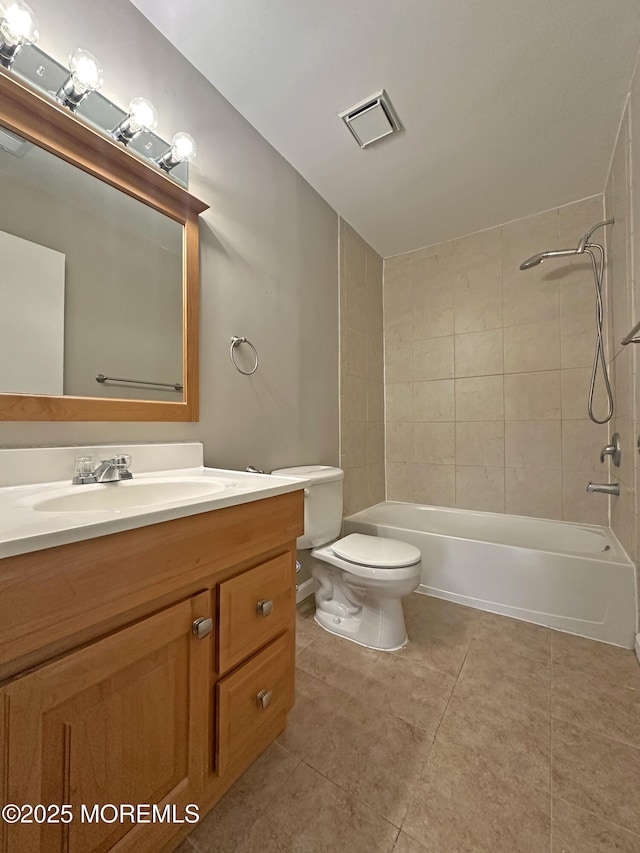 full bathroom with vanity, tile patterned floors, tiled shower / bath combo, and toilet