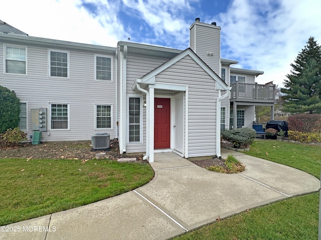 view of front of house featuring a front lawn and cooling unit