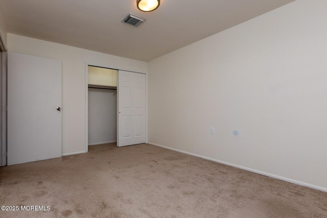 unfurnished bedroom featuring a closet and light colored carpet