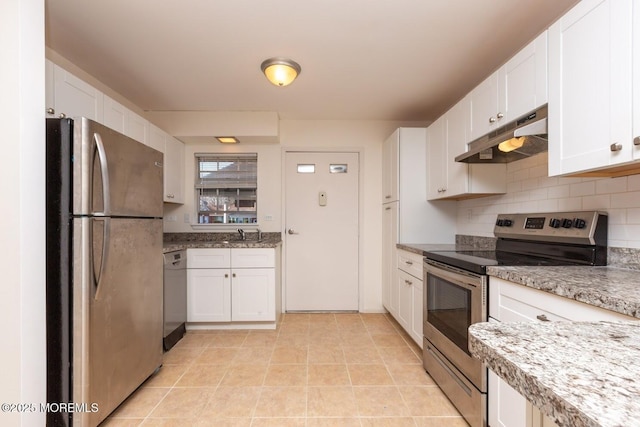 kitchen with light tile patterned floors, stainless steel appliances, white cabinets, and tasteful backsplash