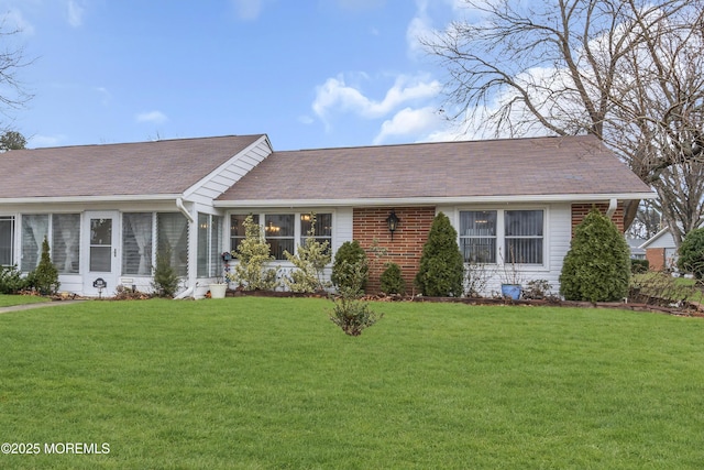 single story home featuring a sunroom and a front lawn