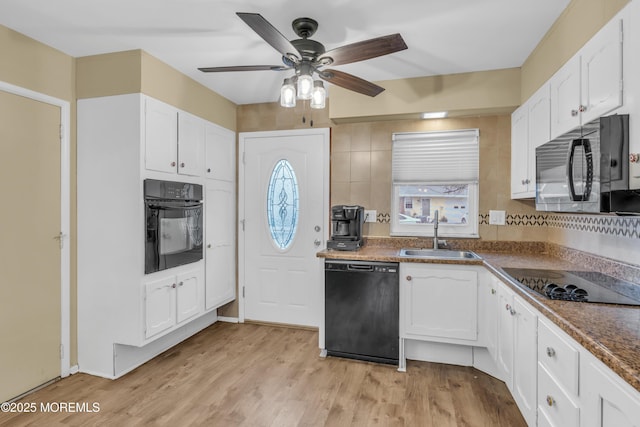 kitchen with white cabinetry, light wood-type flooring, sink, and black appliances