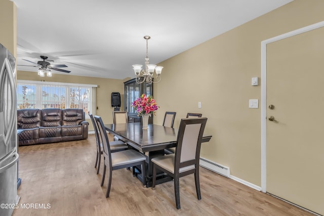 dining area with ceiling fan with notable chandelier, baseboard heating, and light hardwood / wood-style flooring