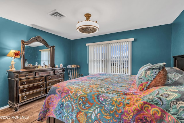 bedroom featuring light hardwood / wood-style floors and multiple windows