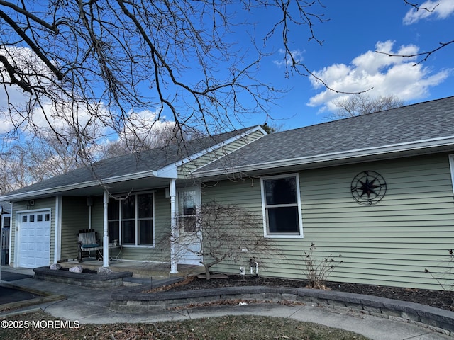 view of front of property featuring a porch, a shingled roof, and an attached garage