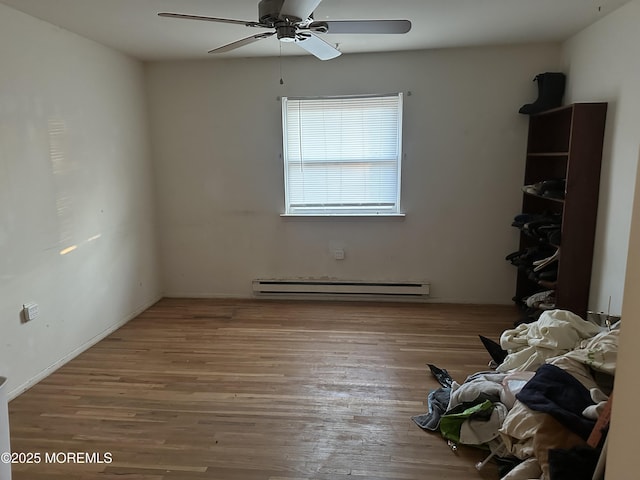 unfurnished room featuring light hardwood / wood-style flooring, baseboard heating, and ceiling fan